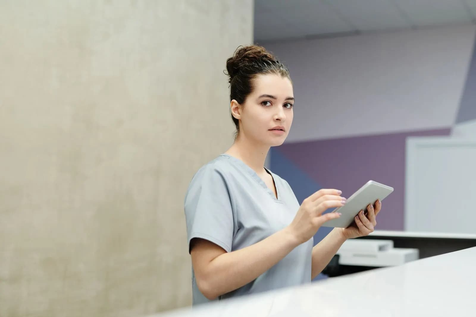 Personne avec une tablette à un comptoir d'accueil