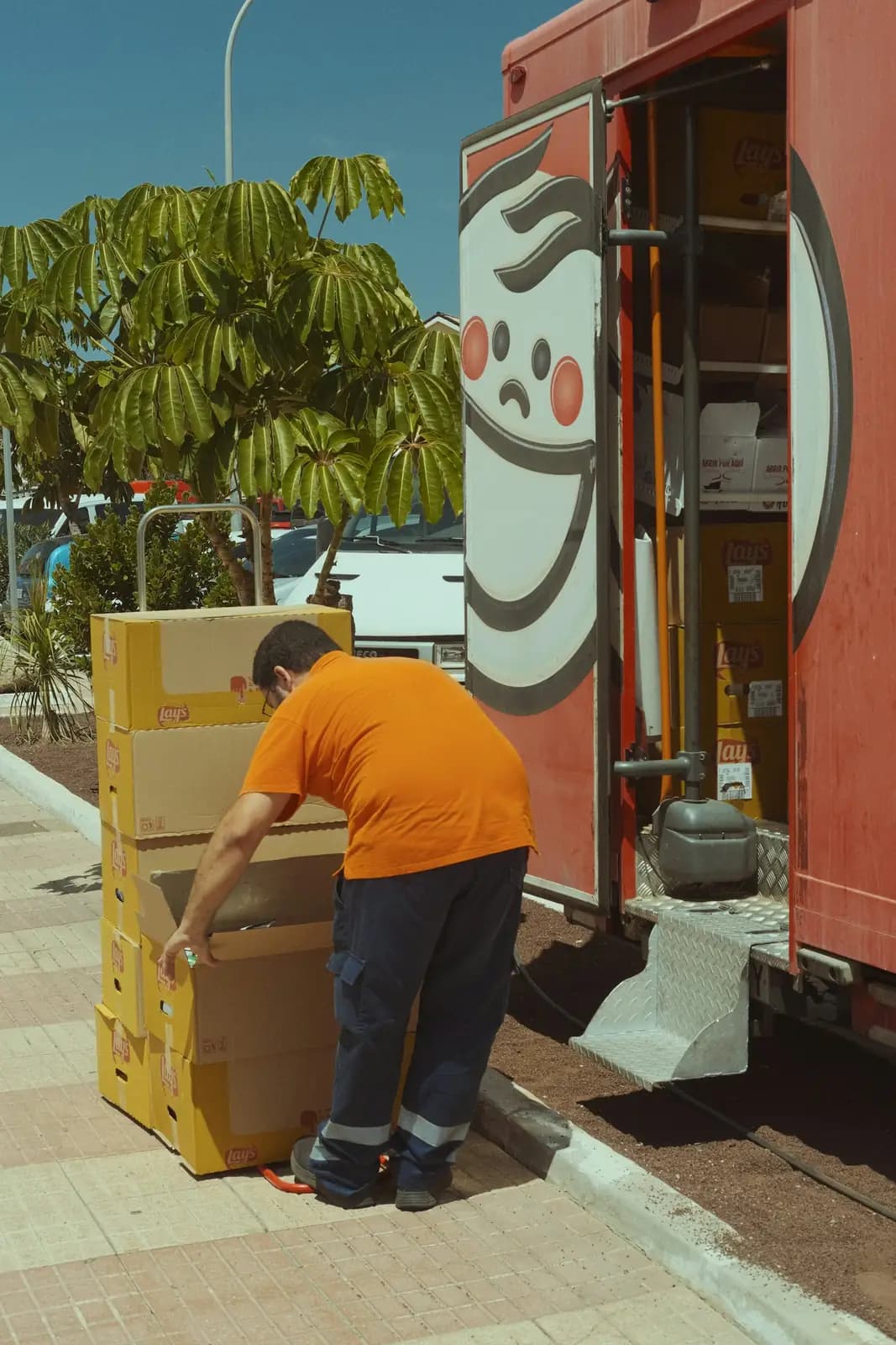 Pessoa movendo caixas empilhadas em um carrinho