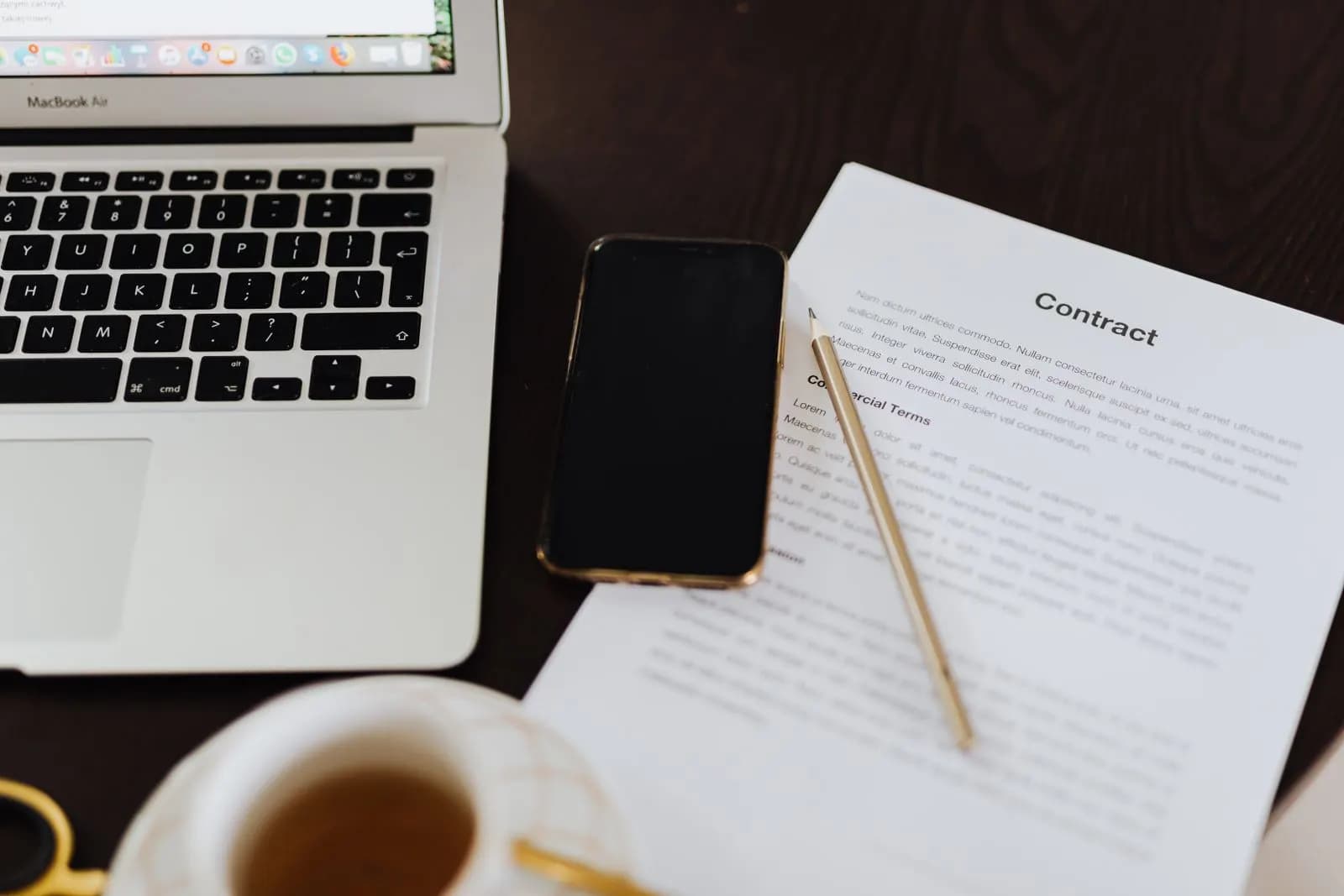Notebook, telefone e papéis sobre uma mesa
