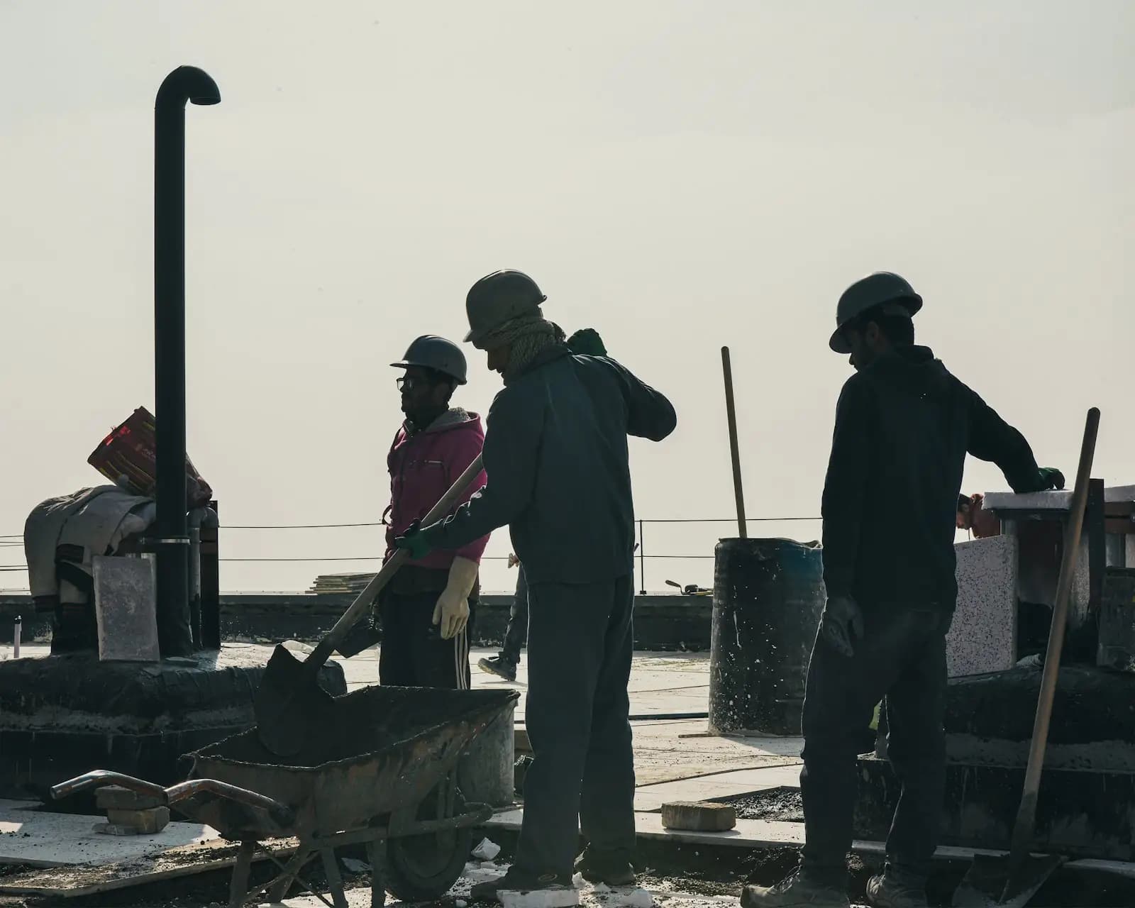 Construction workers in hard hats outdoors on a sunny day